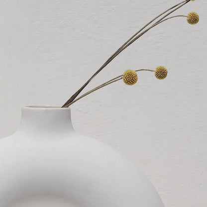 White vase with a branch on a light gray background