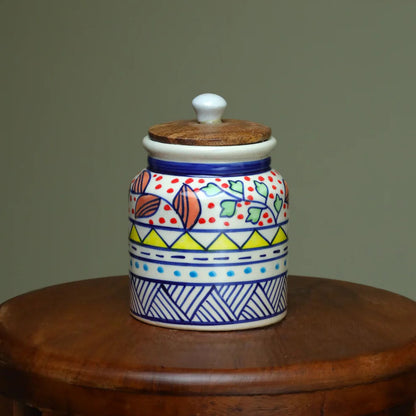 Decorative ceramic jar with colorful patterns on a wooden surface against a plain background