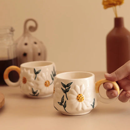 Ceramic mugs with floral designs on a beige surface