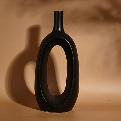 Black vase with unique design on a brown background
