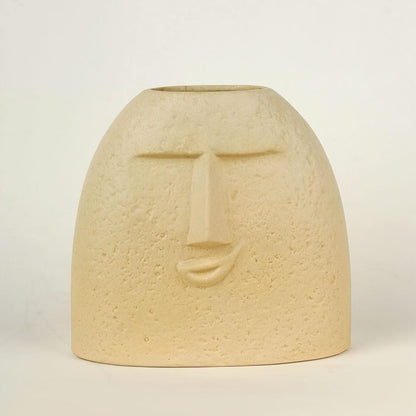 Beige ceramic vase with face design on a light beige background