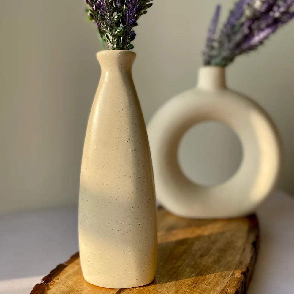 Two ceramic vases with lavender on a wooden surface