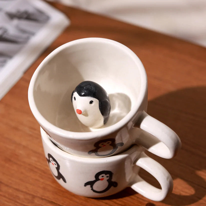 White mug with penguin design on a wooden surface