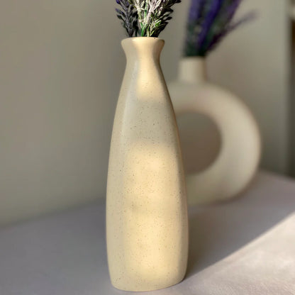 Beige ceramic vase with lavender on a light surface