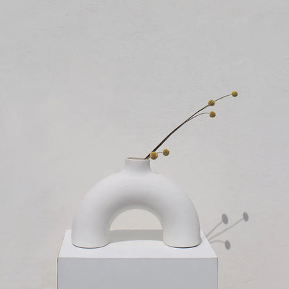 Minimalist white vase with a branch on a light gray background