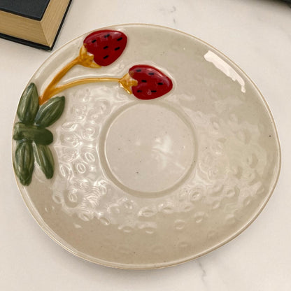 Ceramic plate with strawberry design on a marble surface