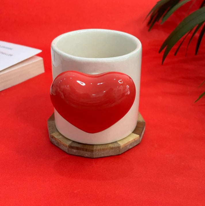 White mug with red heart design on a red background