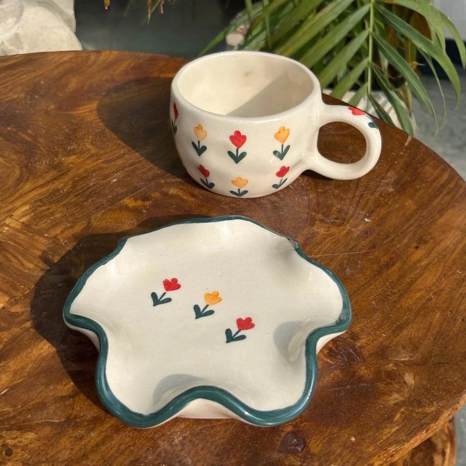 Ceramic cup and bowl with floral patterns on a wooden surface