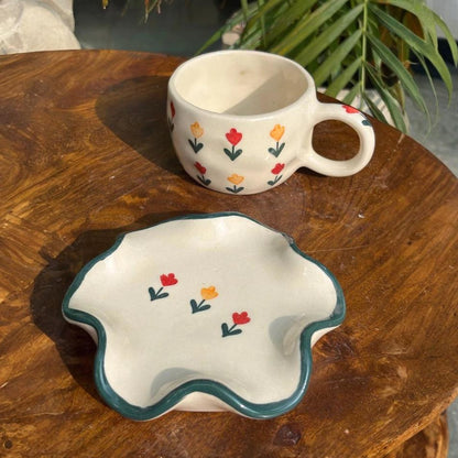 Ceramic cup and bowl with floral patterns on a wooden surface