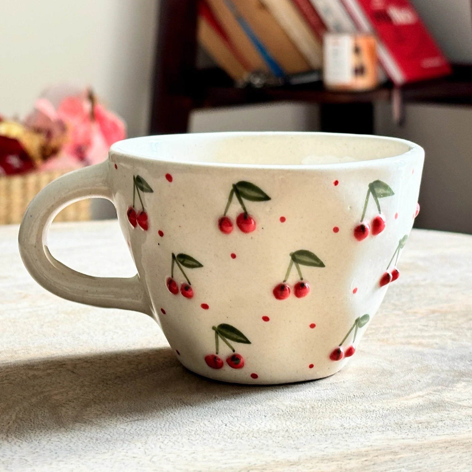 Ceramic mug with cherry design on a wooden surface