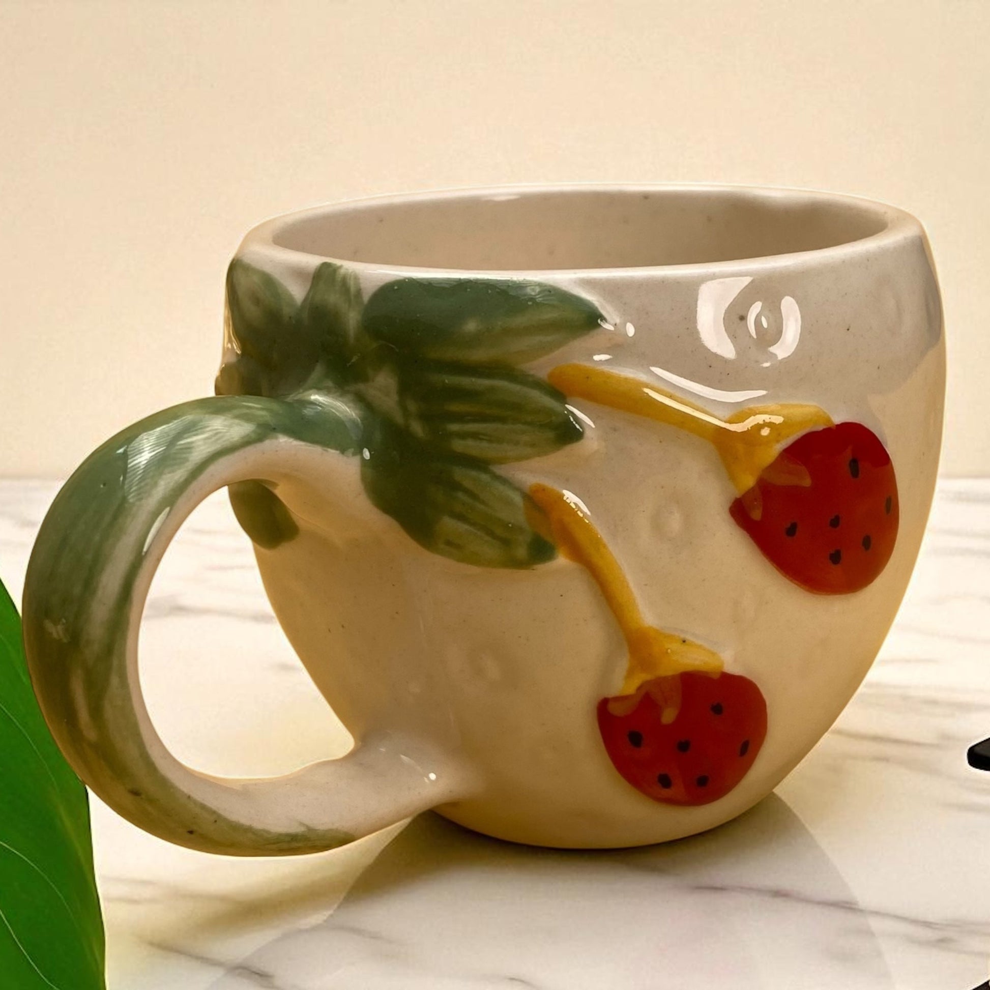 Ceramic mug with strawberry design on a marble surface