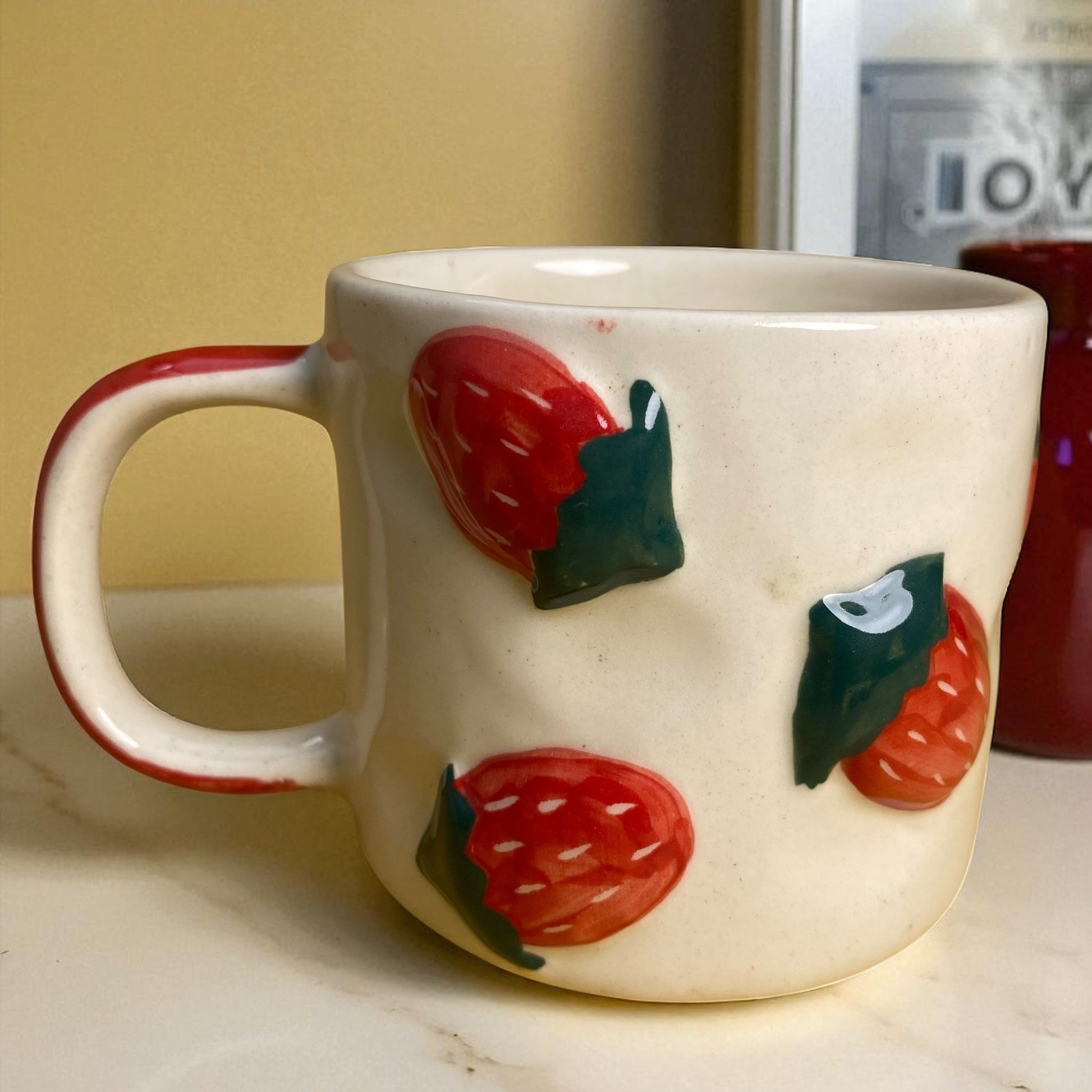 White mug with strawberry design on a wooden surface