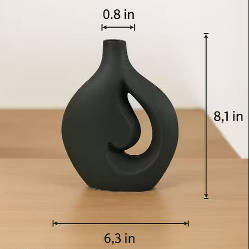 Black decorative vase with measurements on a wooden surface